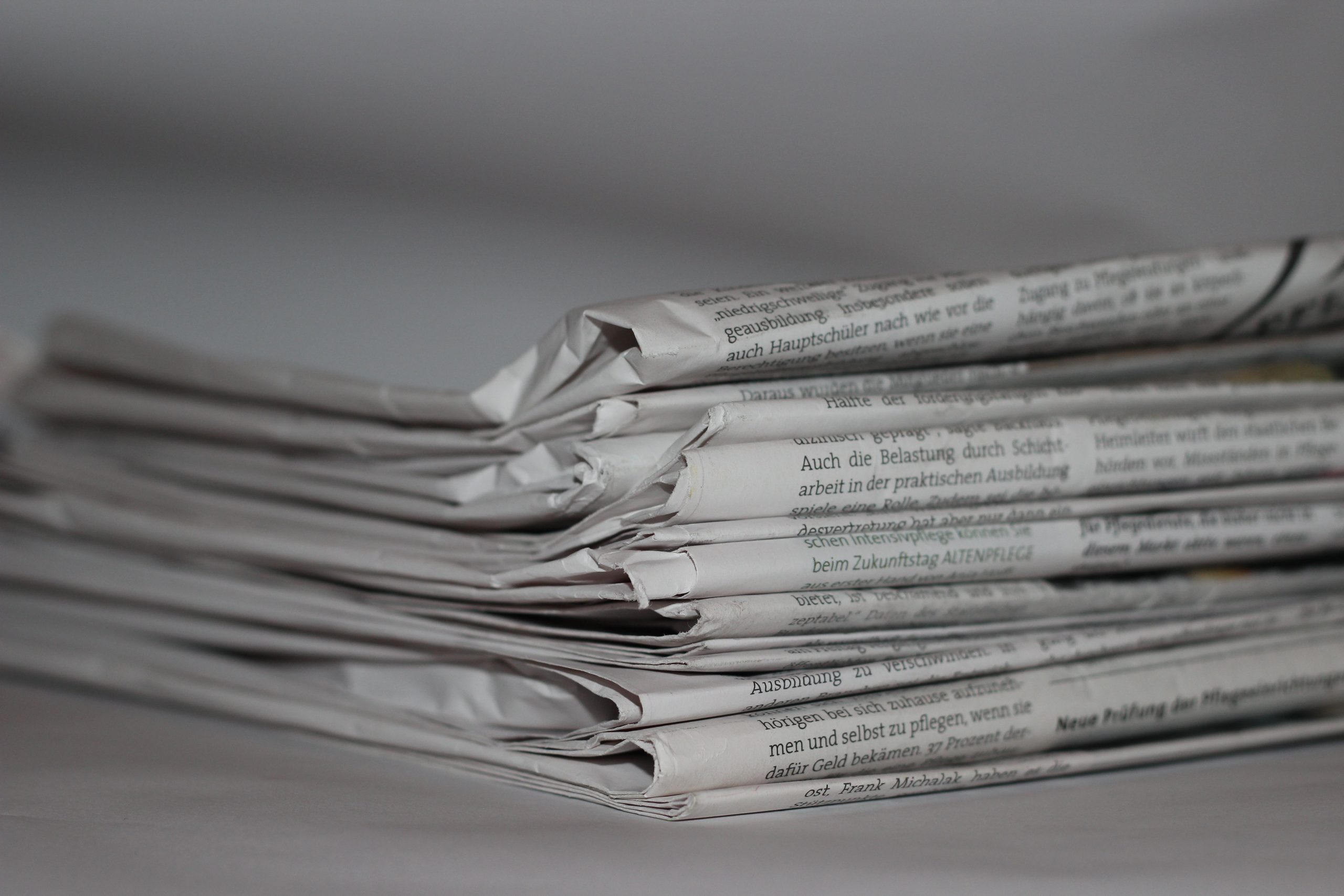 Close-up of folded newspapers, representing news and journalism