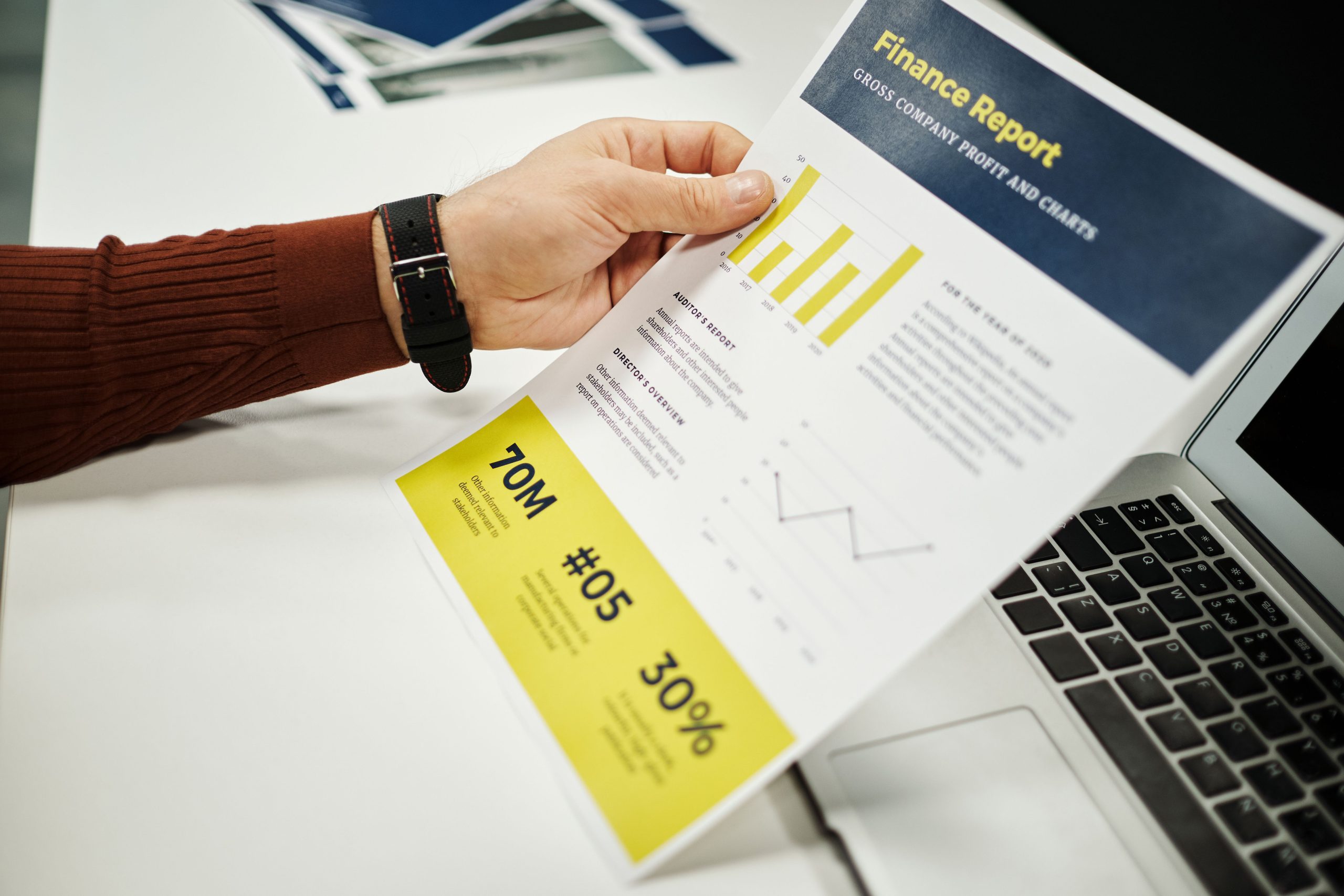 Person analyzing a finance report with graphs and charts at a desk, representing law firm financial reporting