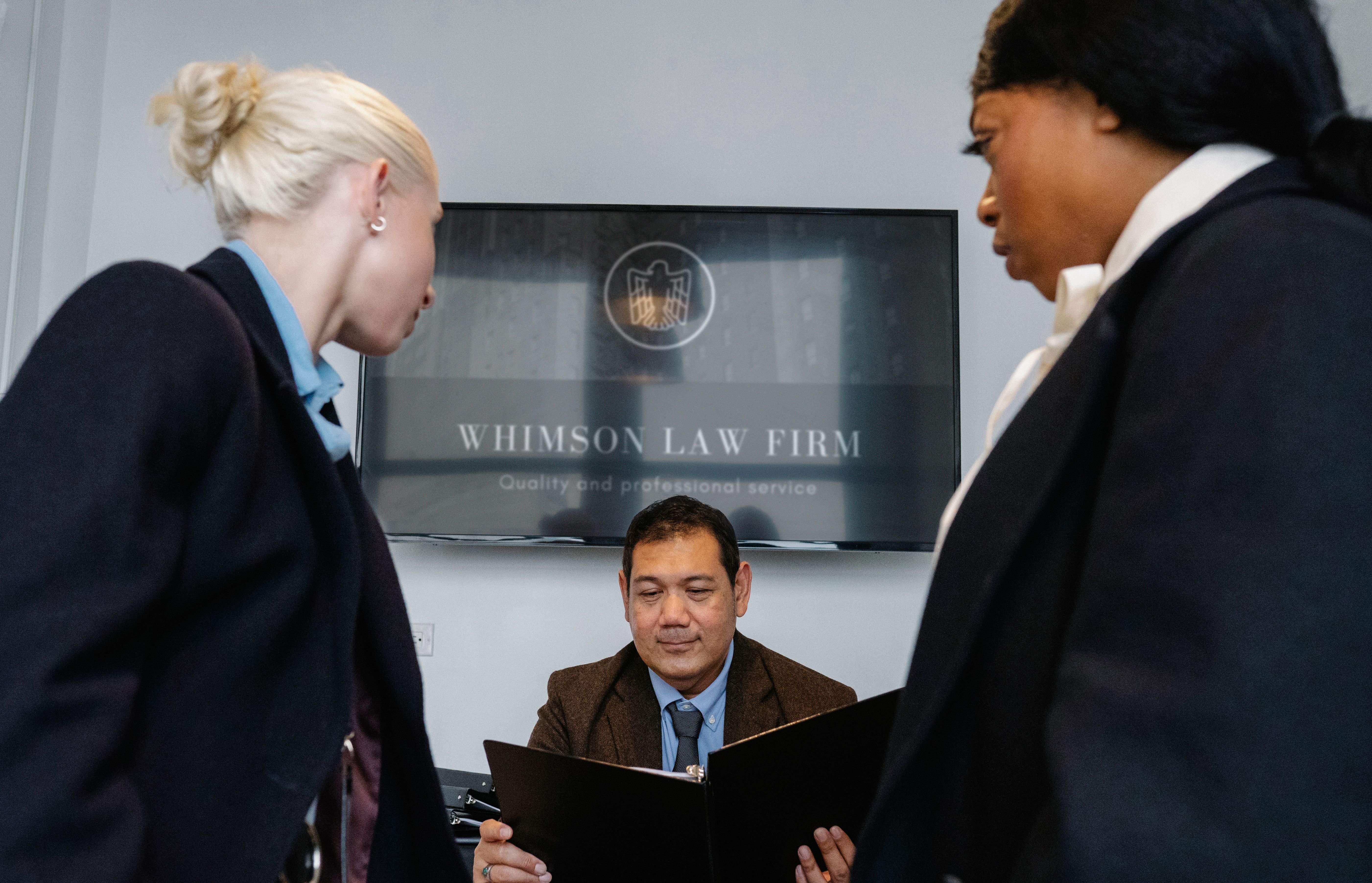 Colleagues gathered in a law firm conference room discussing contract details and financial performance