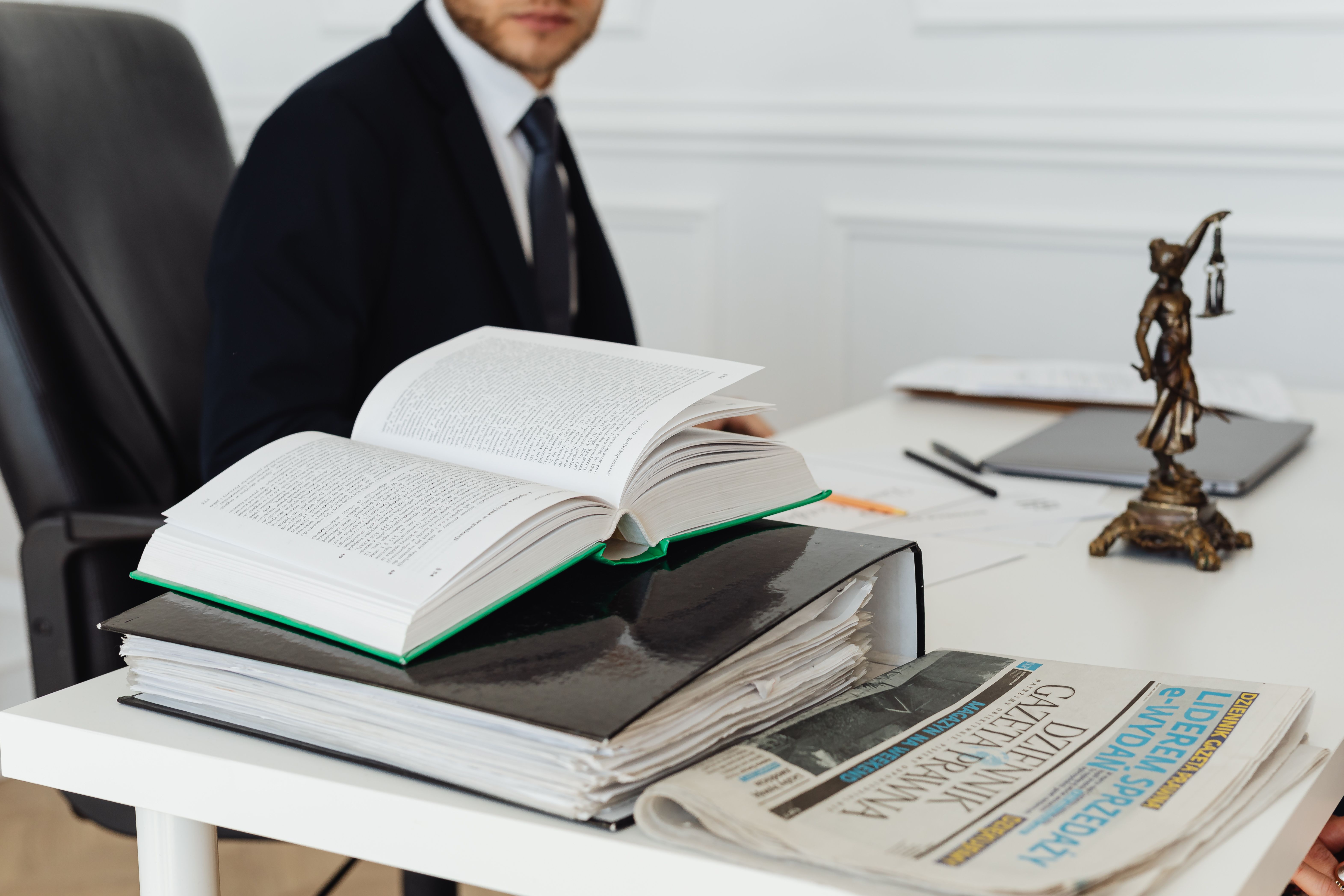 Lawyer sitting at a desk with legal books and documents, embodying professionalism