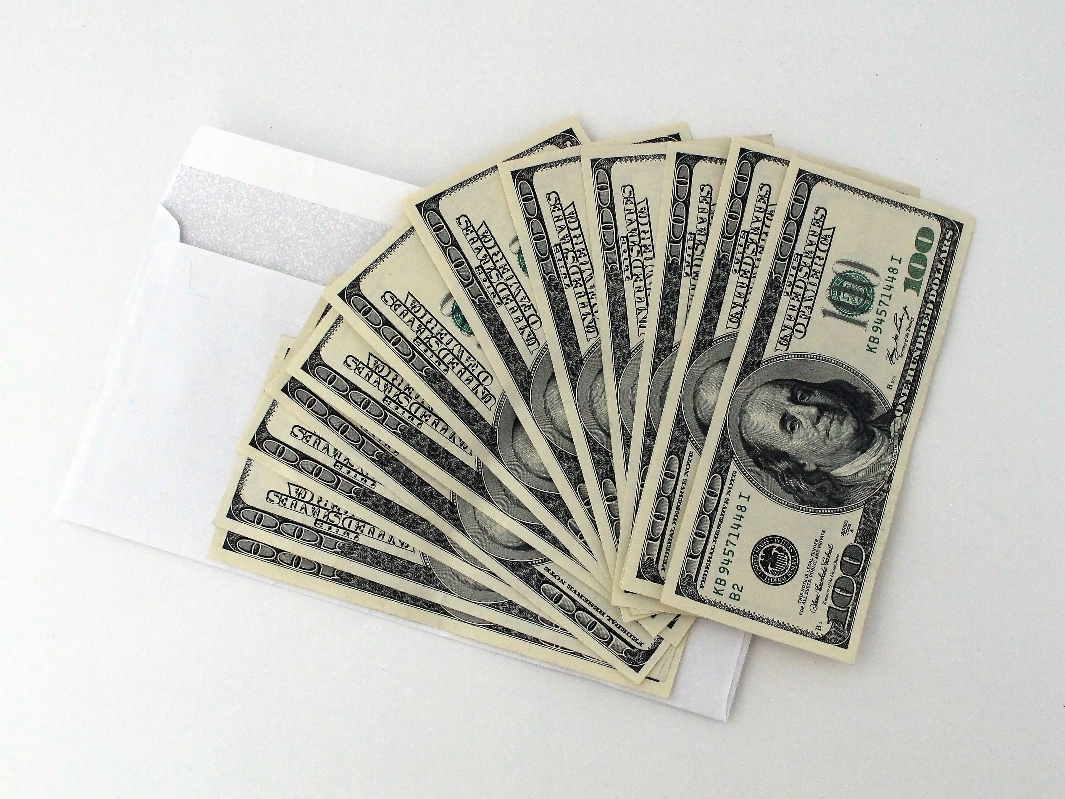 Fan of hundred-dollar bills coming out of an envelope, symbolizing money and political corruption